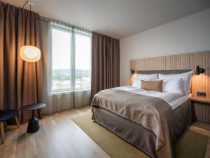 a bedroom with a large bed and a large window at Quality Airport Hotel Værnes in Stjoerdal +71 photos