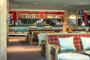 a restaurant with tables and chairs and a bar at Belambra Clubs Tignes Val Claret in Tignes +32 photos