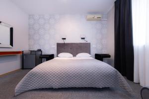 a bedroom with a large bed with two pillows at Hotel Felicia in Riga