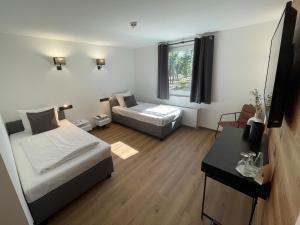 a small room with two beds and a table at Hotel Motodrom in Hockenheim