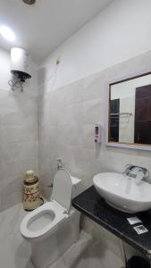 a bathroom with a white toilet and a sink at Samriddhi Homestay in Varanasi