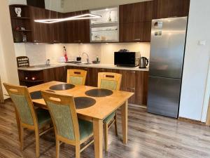 a kitchen with a wooden table and a refrigerator at RIGA street Apartment 54 entire house in Valmiera