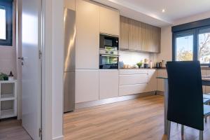 una cucina con mobili bianchi e un tavolo di La Casa Dorada a Santander