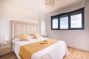 una camera da letto bianca con un letto grande e una finestra di La Casa Dorada a Santander