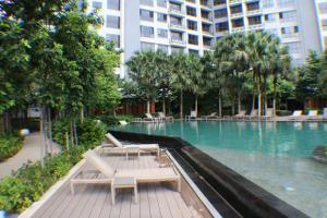 a swimming pool with lounge chairs in a building at KLCC Pavilion Bukit Bintang Agile Hornbill Suites TRX in Kuala Lumpur