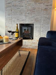 ein Wohnzimmer mit einem Kamin und einem blauen Sofa in der Unterkunft Albert's Cottage, Dorset in Blandford Forum