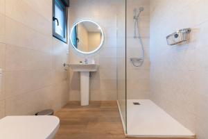 un bagno con doccia, lavandino e specchio di La Casa Dorada a Santander Altre 22 foto