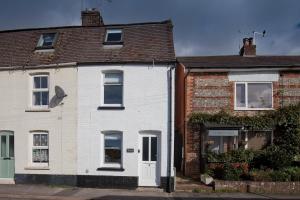 ein weißes Haus mit braunem Dach in der Unterkunft Albert's Cottage, Dorset in Blandford Forum