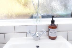 eine Flasche Seife auf einem Waschbecken in der Unterkunft Albert's Cottage, Dorset in Blandford Forum + 24 Fotos