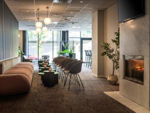 a lobby with a row of chairs and a fireplace at Quality Airport Hotel Værnes in Stjoerdal