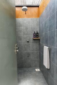 een badkamer met een douche met grijze tegels bij Nairobi Botanical Retreat - Container Home in Nairobi