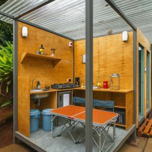 een buitenkeuken met een tafel en stoelen in een schuur bij Nairobi Botanical Retreat - Container Home in Nairobi +10 foto's