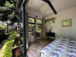 een slaapkamer met een bed en een aantal ramen bij Nairobi Botanical Retreat - Container Home in Nairobi