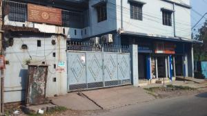 een wit gebouw met een poort op een straat bij Maa Durga Apartment in Dhanbad