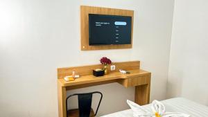 a small wooden table with a tv on a wall at The Cabin Hotel Sumberan Baru in Ngabean