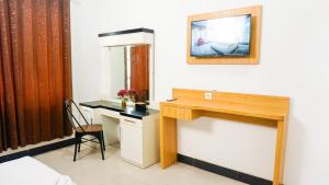 a room with a desk with a chair and a mirror at The Cabin Hotel Sumberan Baru in Ngabean