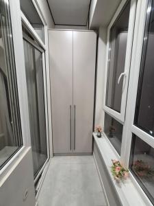ein Flur mit zwei Fenstern und einem weißen Schrank in der Unterkunft Love & Happiness in Almaty + 26 Fotos