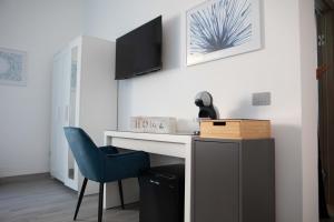 SestuにあるMhometredici Camera doppia Otelloのデスクと青い椅子が備わる客室です。 +1枚の写真