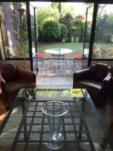 a living room with a glass coffee table and a patio at L'étape Impressionniste in Croissy-sur-Seine