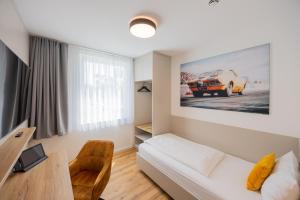 a living room with a white couch and a table at Hotel Motodrom in Hockenheim