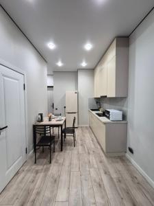 eine Küche mit Tisch und eine Küche mit weißen Schränken in der Unterkunft Love & Happiness in Almaty