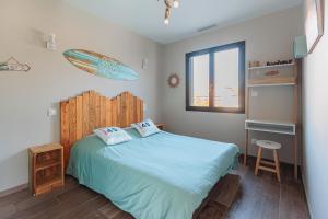 a bedroom with a bed with a surfboard on the wall at Belle Villa, Evasion Landaise in Azur +23 photos