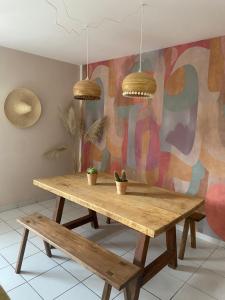 a wooden table with potted plants and two pendant lights at Gîte Minimalist indépendant au calme in Commentry