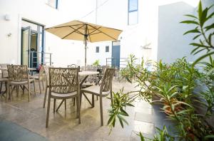 Un patio con una mesa y sillas y una sombrilla. en Hotel Fantazia Oradea - Self Check In & Out, en Oradea