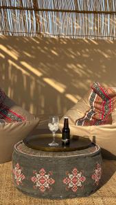 a table with a glass and a bottle of wine at FYAFY Bidiyah Bedouin Camp in Bidiyah