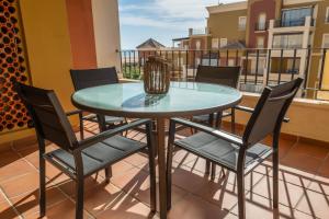 a glass table and chairs on a balcony at Playa Grande - Playa Punta del Moral PPHG150P104 in Isla del Moral