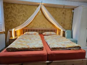 a bedroom with a bed with a canopy and two chairs at Das blaue Haus in Pleisweiler-Oberhofen +69 photos