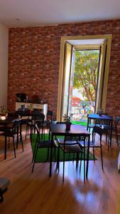 Un comedor con mesas y sillas y una pared de ladrillos. en Hostel Dolce di Monica, en Nápoles