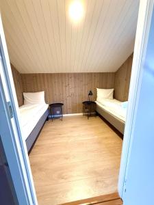 two beds in a small room with a table at KB Fisherman Cabin - NR3 - Stamsund in Stamsund