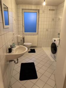 a bathroom with a sink and a toilet and a window at Monteurwohnung L770-2 in Stemwede