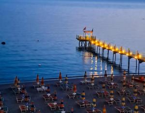 a pier with chairs and lights on the water at Kaya by Keshtjella in Durrës