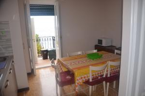 a kitchen with a table and chairs with a green bowl on it at Della Pace Apartment in Tellaro