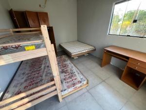 une chambre avec deux lits superposés et un bureau dans l'établissement Casa no Lago em Corumbá 4, à Alexânia