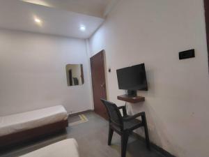 Zimmer mit einem Bett, einem Stuhl und einem TV in der Unterkunft Hotel O Karond Square Bus Terminal Bhopal Formerly Hotel Munmun in Bhopal