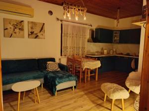 een woonkamer met een groene bank en een keuken bij Rooster Retreat in Aridaía +17 foto's