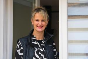 a woman standing in front of a door at O Cottage E Lavisse in Le Nouvion-en-Thiérache