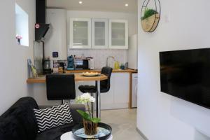 a living room with a couch and a table with chairs at O Cottage E Lavisse in Le Nouvion-en-Thiérache
