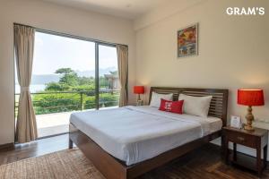 Un dormitorio con una cama y una ventana grande. en Gram's at Shivom, Pawna Lake, en Lonavala