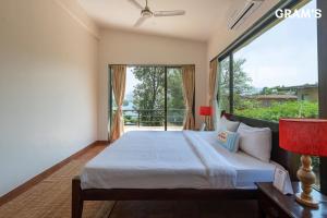 Un dormitorio con una cama y una ventana grande. en Gram's at Shivom, Pawna Lake, en Lonavala 92 fotos más