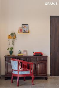 una silla roja frente a un escritorio de madera en Gram's at Shivom, Pawna Lake, en Lonavala