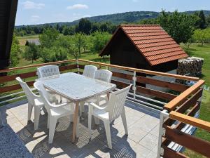 een witte tafel en stoelen op een patio met uitzicht bij Guesthouse Zafran in Smoljanac