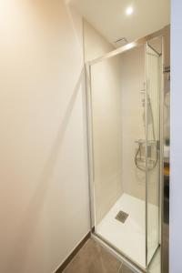 a shower with a glass door in a bathroom at Le 240, entre lac et montagnes in Les Rousses