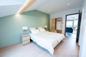 a bedroom with a large white bed and a window at Le 240, entre lac et montagnes in Les Rousses