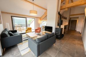 a living room with two couches and a fireplace at Le 240, entre lac et montagnes in Les Rousses