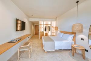 a bedroom with a large white bed and a desk at B&B Marina Garden in Ischia