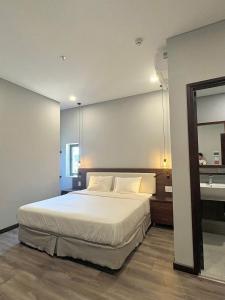 a bedroom with a large bed and a mirror at Silana Riverfront Danang in Da Nang